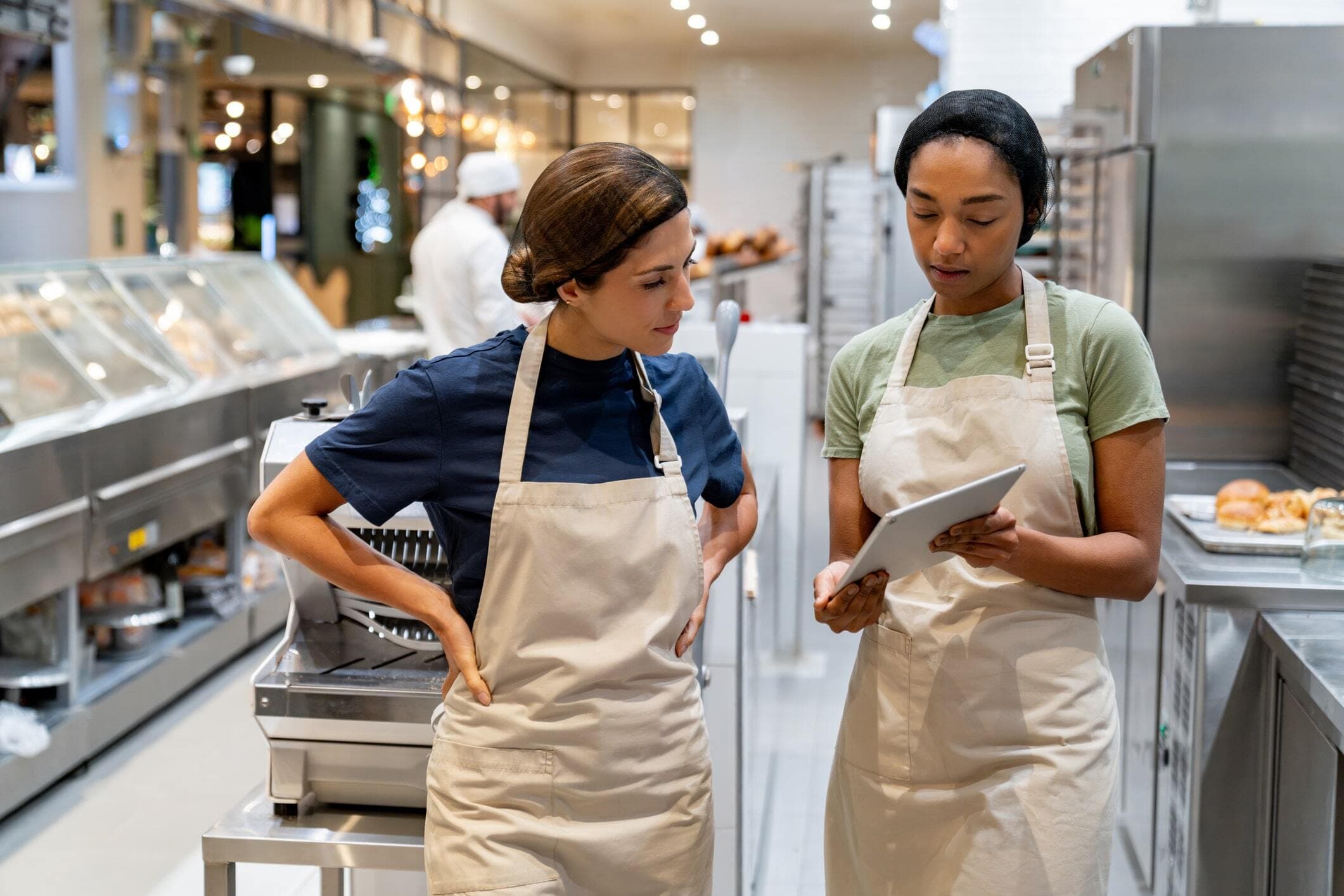 Two bakery staff checking a tablet together