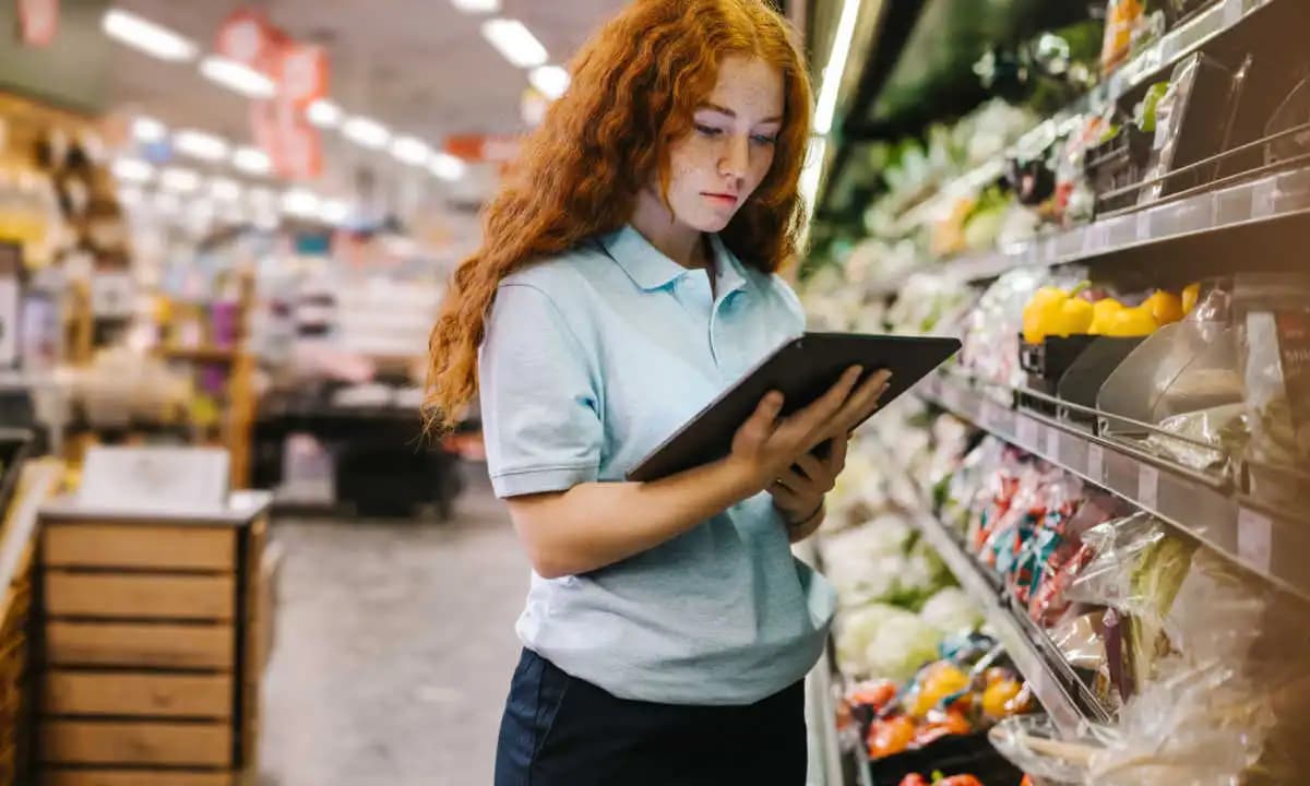 A new employee checking stock against a tablet